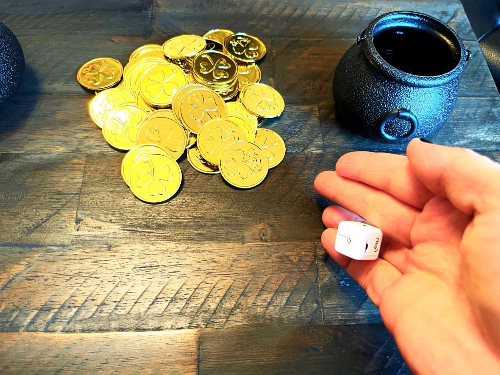 pot of gold coins with hand rolling rhythm die dice