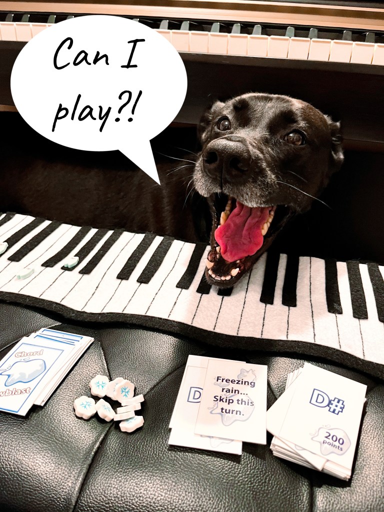 black labrador retriever lab mix dog wants to play chord card game at the piano keyboard with speech bubble saying can i play