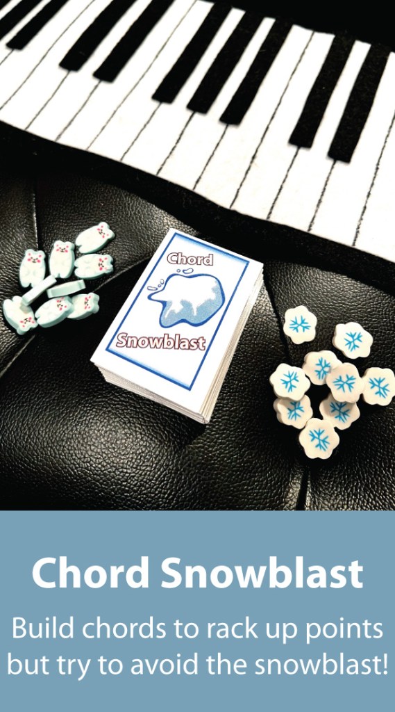 A felt piano sits on top of a black piano bench. Below are polar bear and snowflake mini-erasers flanking a deck of cards for the piano game Chord Snowblast.