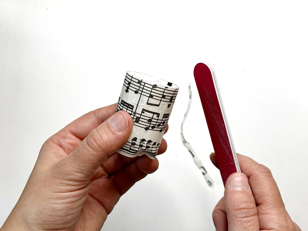 Photo show the napkin easily falling off by using the nail file. This method leaves a clean edge along the candle. 