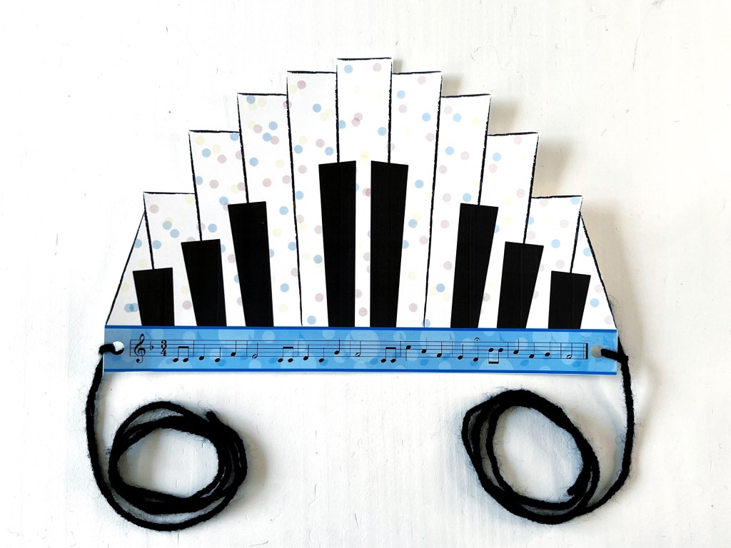 Completed piano birthday crown lays on top of a white table.