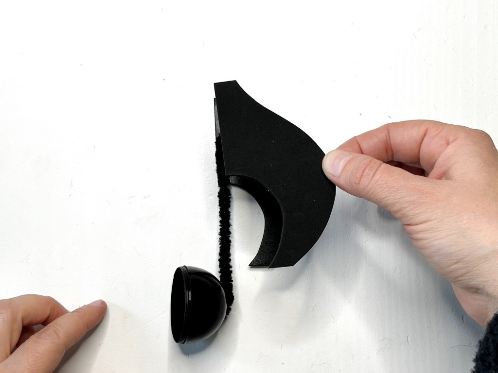 Two black self adhesive craft foam eighth note flags are glued together.