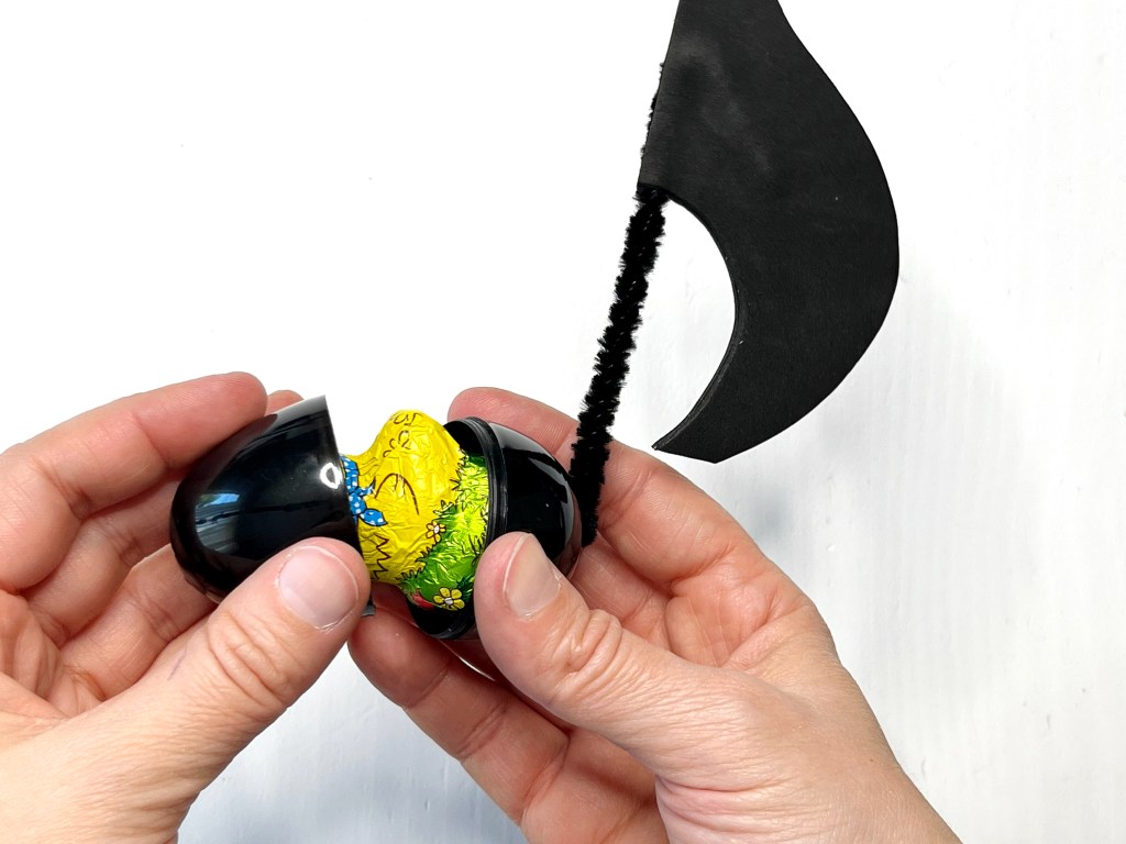 A plastic egg music note is loaded up with a piece of chocolate