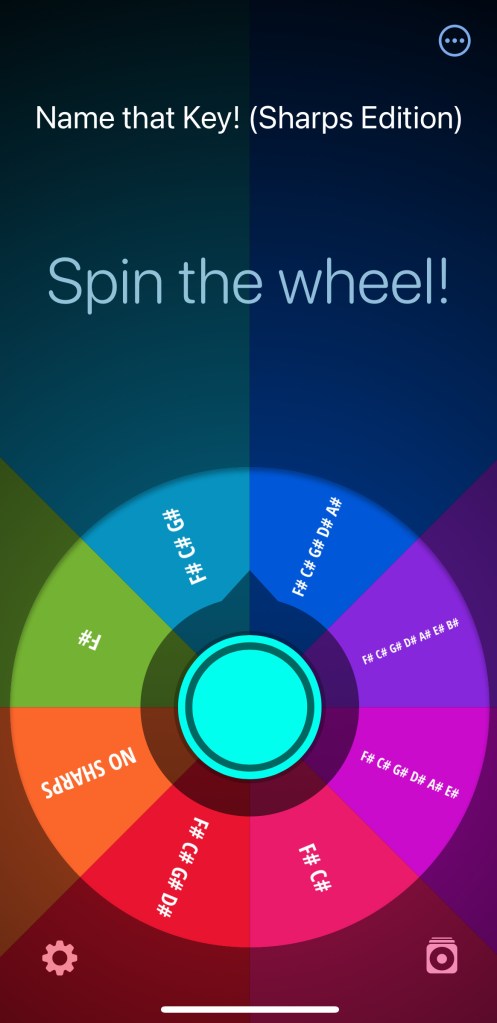 A rainbow colored wheel of fortune sits under the words Spin the wheel! The name of the wheel is Name that Key! (Sharps Edition).