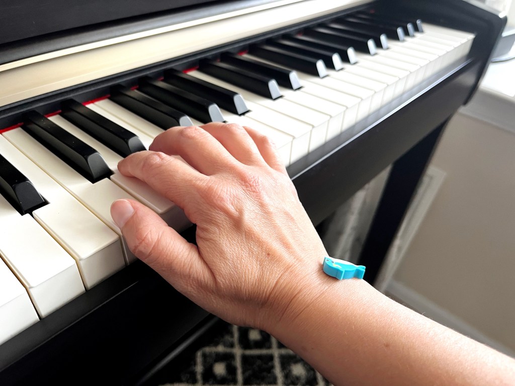A blue dolphin min-eraser fell off the back of the hand due to poor hand posture at the piano, a sagging wrist.