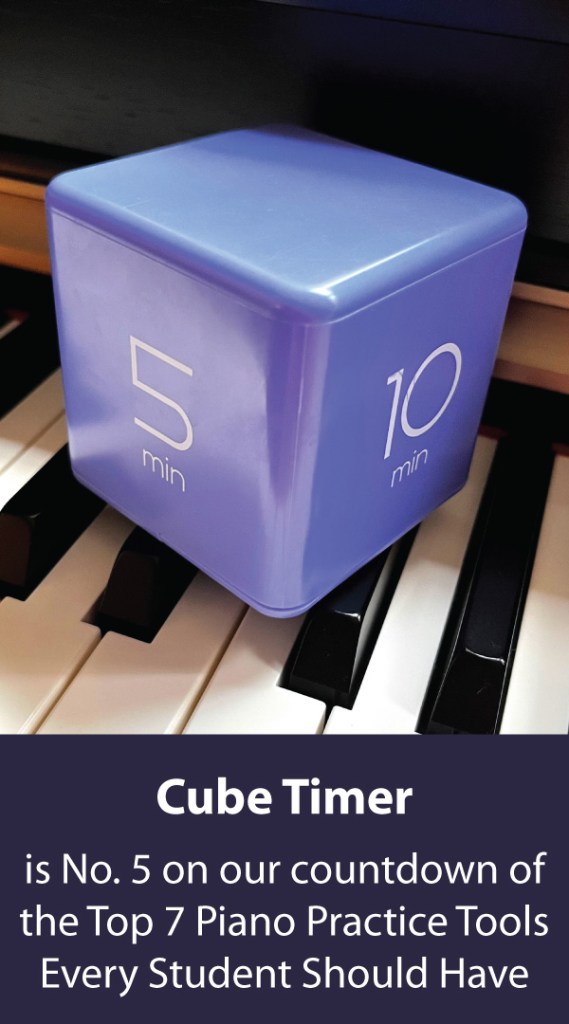 A purple cube timer sits on top of a piano.