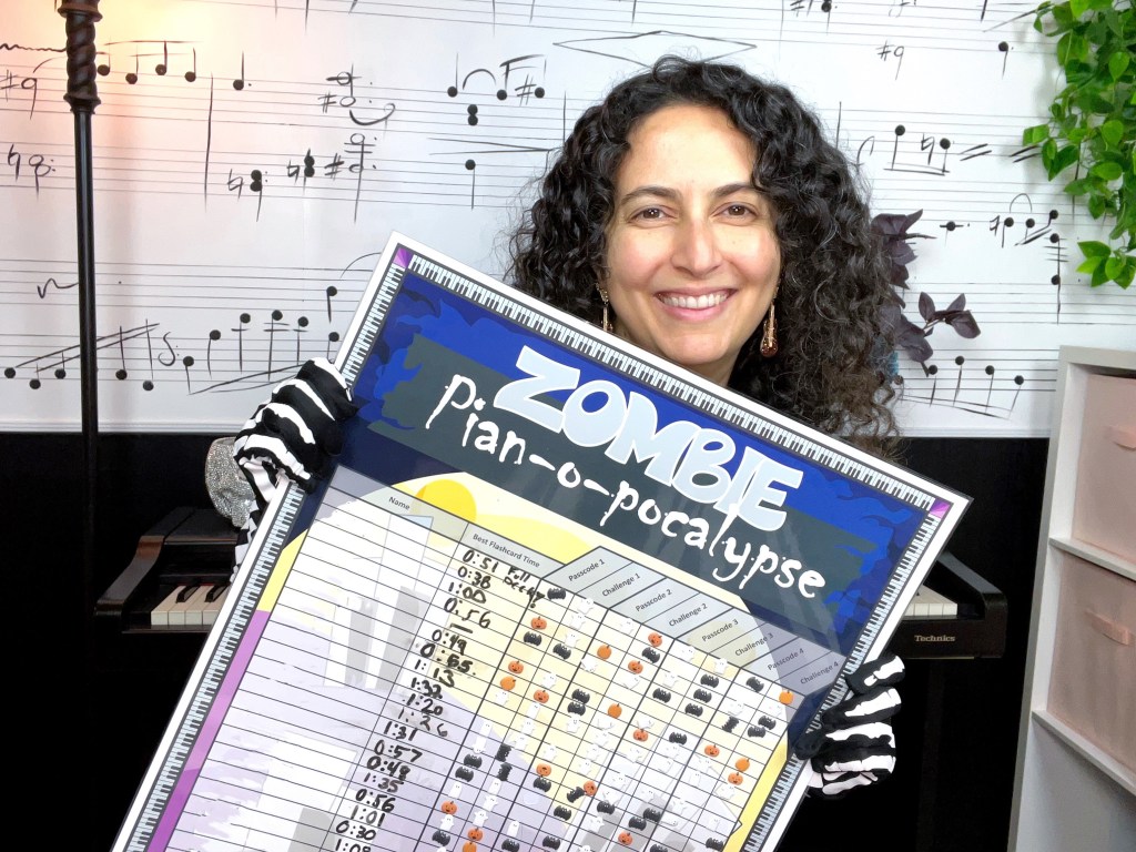 Piano teacher holds up the completed Zombie Piano apocalypse poster.