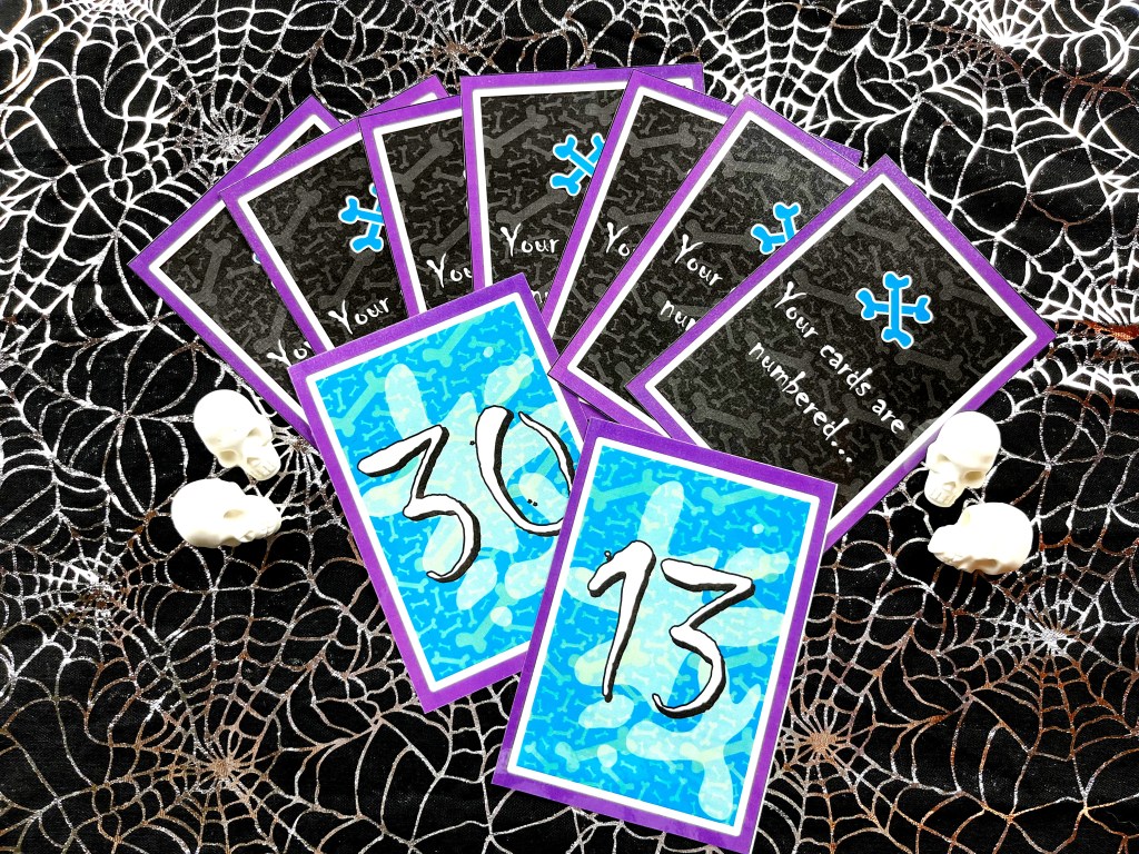 The second deck of the Zombie Race flashcard game is spread out on a spiderweb tablecloth.