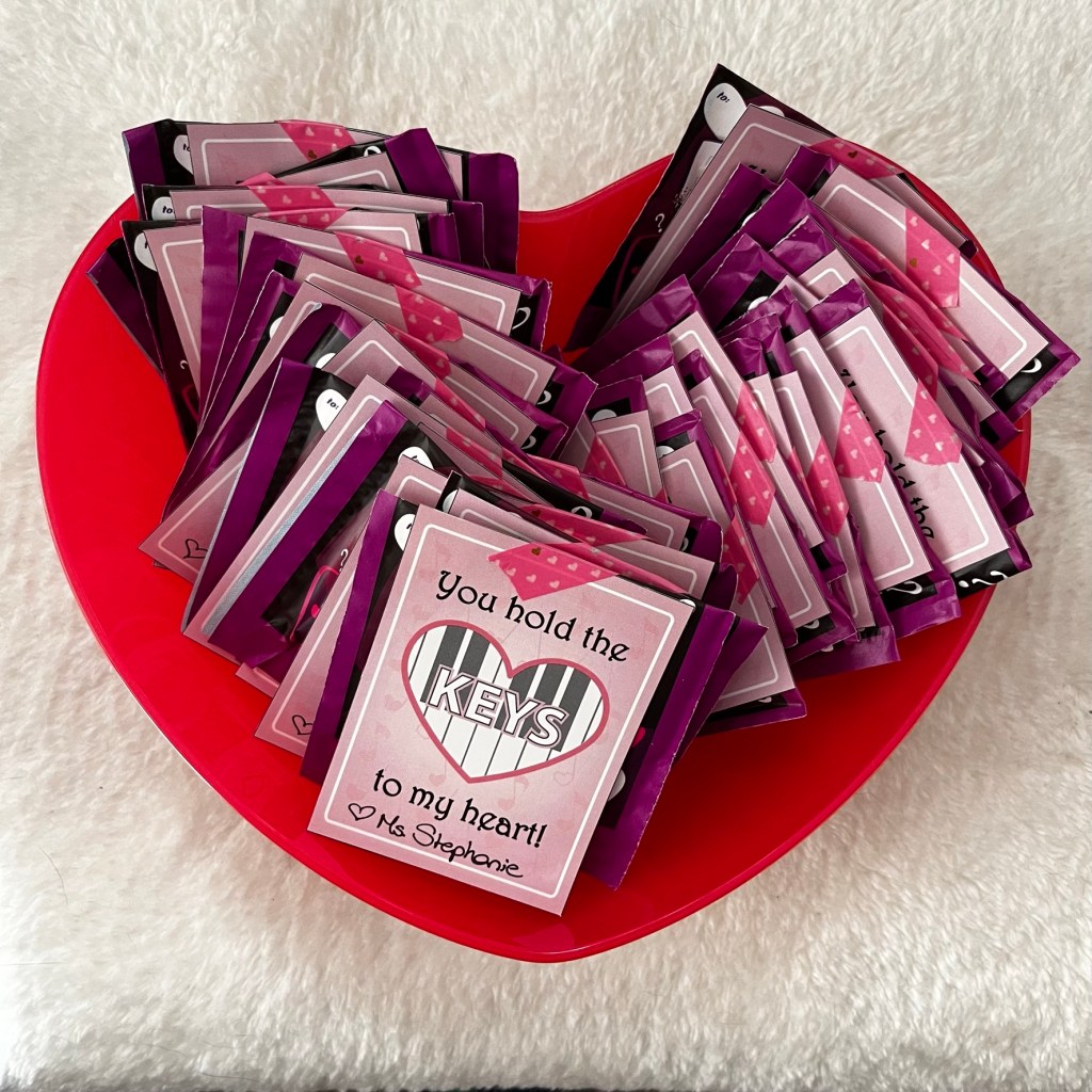 Piano-themed Valentine's day cards sit inside a heart-shaped bowl. 