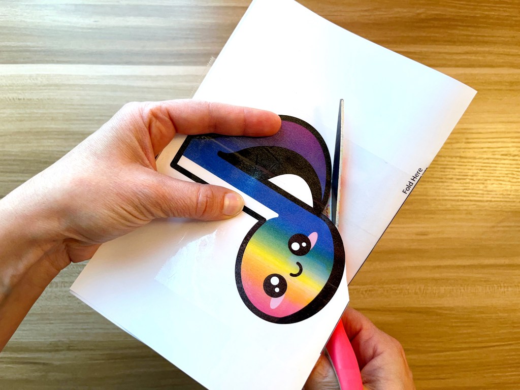 Cutting out a rainbow colored paper eighth note squishy 