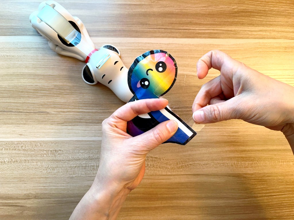 Sealing the open edge of a paper eighth note squishy with transparent tape