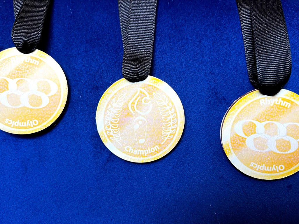 The gold champion medal sit on a velvety blue background
