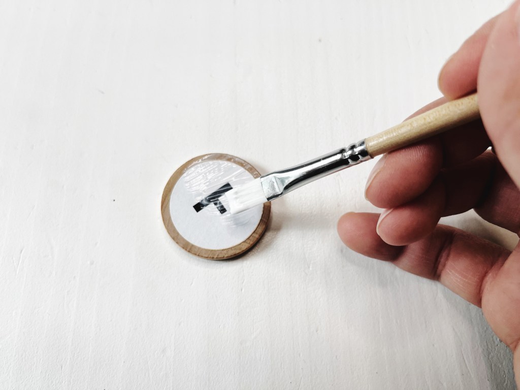 The top of the wood coin and label is sealed with Mod Podge.