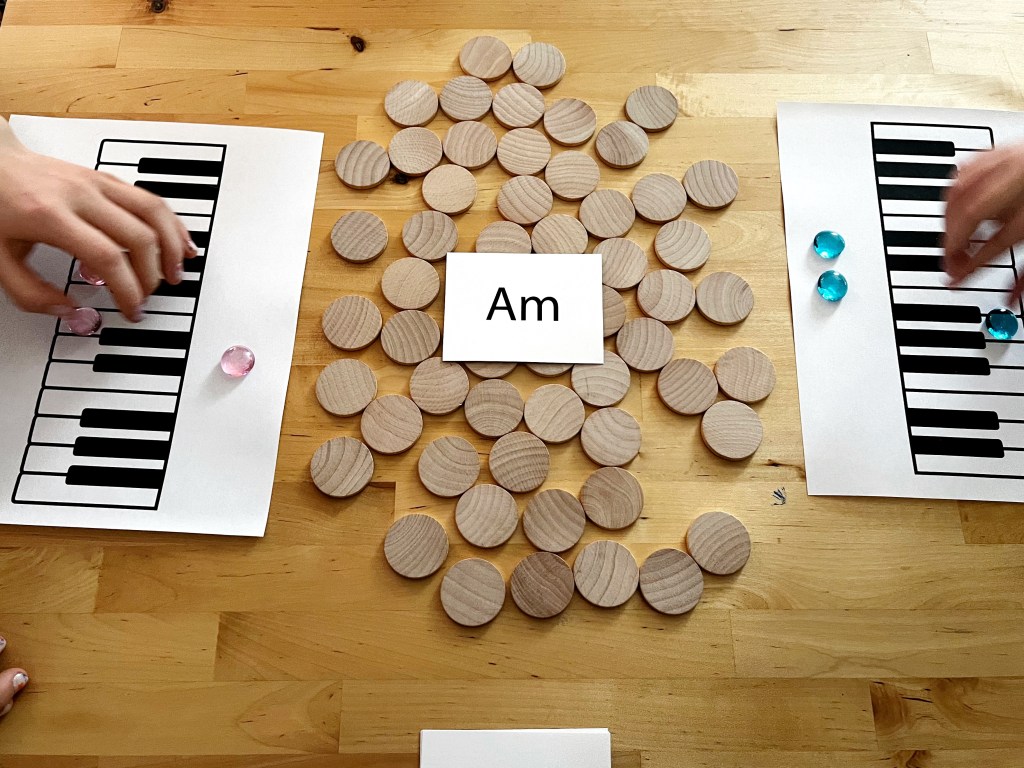 Piano students place their gamemarkers on their keyboards to create an A minor chord.