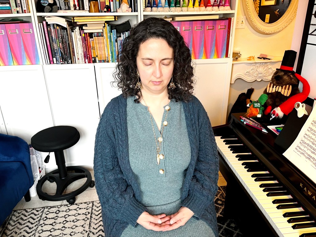 A piano student meditates at the piano.