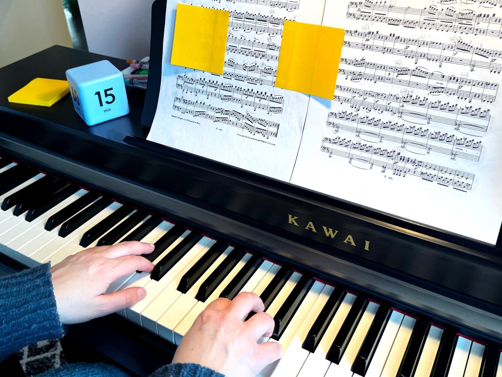 A piano student practices using post-it notes to focus in on a specific portion of their piece.