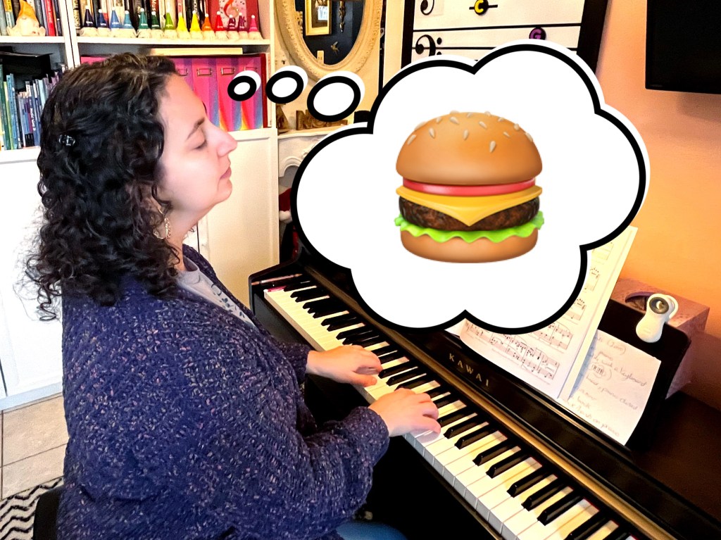 A piano student thinks about a cheeseburger while practicing the piano.