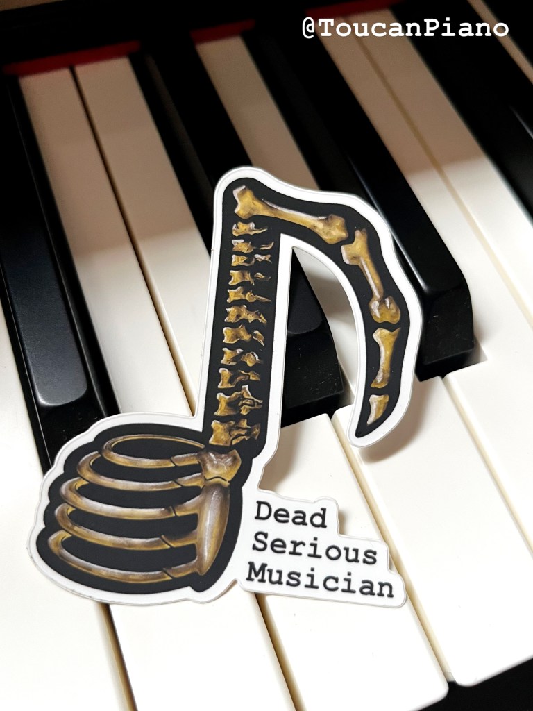 A vinyl sticker shaped like a musical note, designed with a skeleton motif, resting on a piano keyboard. The sticker features the text 'Dead Serious Musician'.